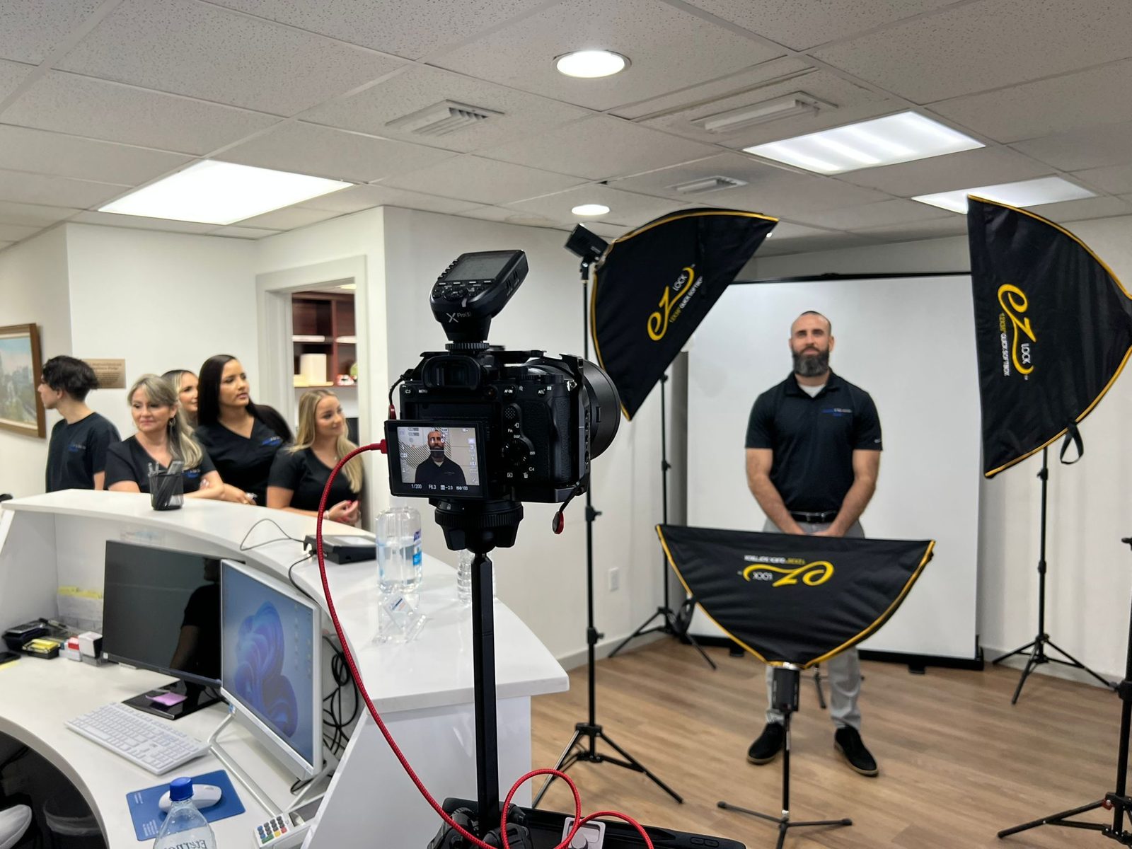 Office headshot day with the team gathered around